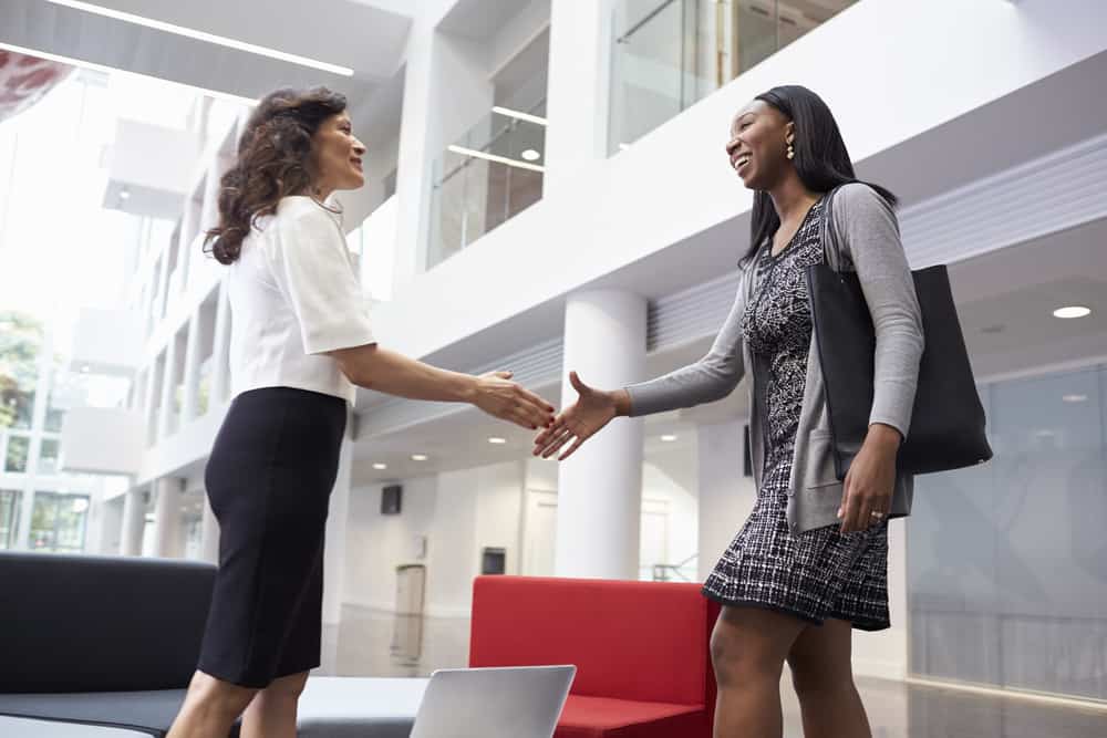 2 women shaking hands in lobby