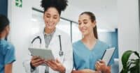 Someone sharing best documentation practices that they learned from Harmony Healthcare to a physician